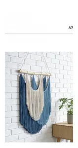 Detail of bohemian hand-woven tapestry with navy blue and cream tassels on wood beam