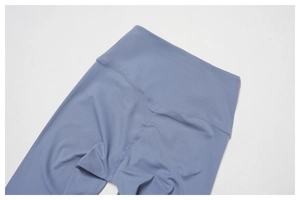 Detail view of high-waist yoga leggings featuring flatlock stitching and soft blue fabric