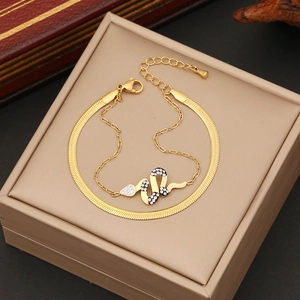 Detailansicht eines goldenen Schlangenanhängers mit Strass auf einer Schlangenkette