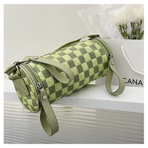 Detail of green checkerboard cylinder bag with embossed texture and wide strap