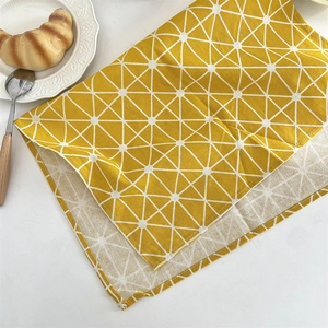 Texture détaillée d'un set de table jaune en coton et lin aux motifs géométriques