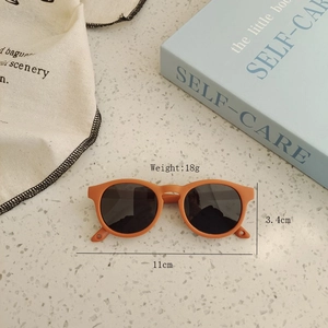Top view of orange silicone toddler sunglasses with dimensions and lifestyle props