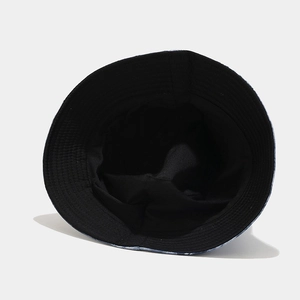Dettaglio del cappello alla pescatora reversibile con motivo tie-dye blu-nero e cuciture