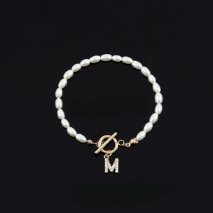 Elegant oval pearl beaded bracelet with a gold OT toggle clasp and crystal M charm