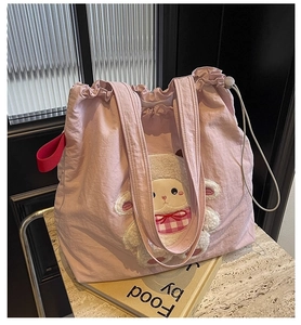 Detail of pink canvas tote bag featuring a cute lamb fleece applique and red side strap