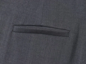 Detail of slanted pocket stitching and dark gray twill wool texture on trousers