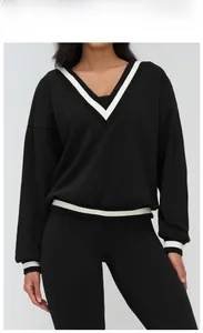 Detailed close-up of V-neck cuffs with contrast white stripes on black sports sweatshirt