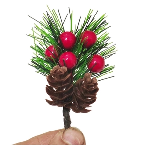 Detailed close-up of artificial pine needles with red berries and brown pine cones