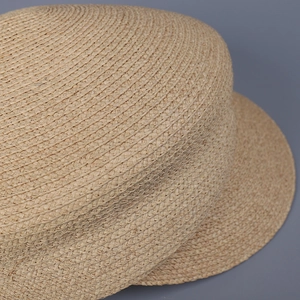 Macro view showing the detailed texture of natural raffia weaving on a summer hat