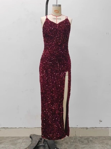Détail de la robe à paillettes bordeaux montrant la fente haute et la coupe de soirée