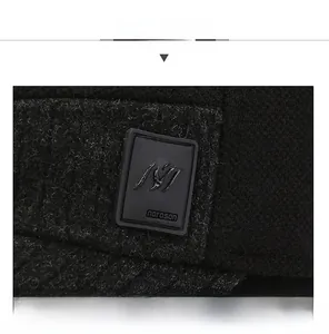 Detail shot of black knitted fabric texture and premium square rubber logo on the winter hat