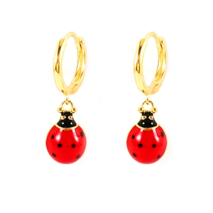 Close-up of gold ladybug hoop earrings with red and black enamel finish on white background