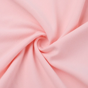Gros plan sur la maille rose montrant la texture dense et la douceur du matériau