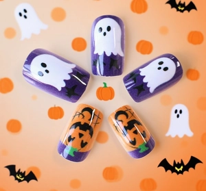 Λεπτομέρεια από τεχνητά νύχια Halloween με σχέδια από μωβ φαντάσματα και πορτοκαλί κολοκύθες