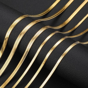 Macro view of golden stainless steel flat snake bone necklaces in various widths