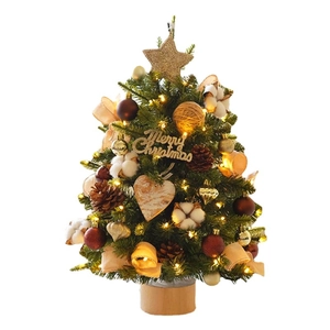 Mini lighted Christmas tree with gold ornaments, pine cones, and a wooden base on white background