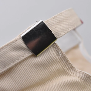 Detail of light beige twill cotton baseball cap with a polished metal adjustment buckle