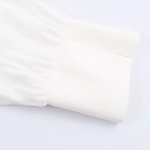 Detail of the white shirt cuff featuring fine plain weave fabric and precise stitching