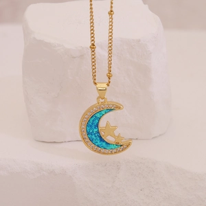 Détail du collier lune et étoile avec opale bleue sur un support en pierre