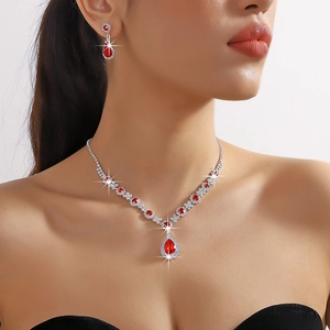 Close-up of sparkling red pear-cut crystal necklace and earrings set with silver finish