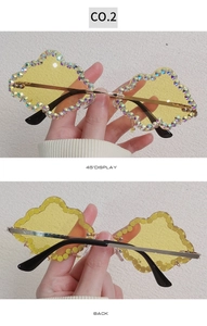 Detail of yellow cloud-shaped rimless sunglasses with colorful rhinestones and gold temples