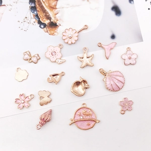 Pink and gold enamel charms collection featuring shells, flowers, and sea motifs