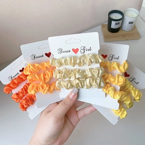 Neon satin scrunchies set in bright warm colors with a premium glossy silk finish