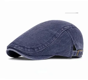 Detail view of navy blue washed denim flat cap showing twill texture and side metal buckle