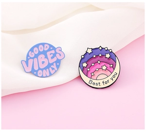 Close-up of enamel pins with Good Vibes Only and Best for you inspirational quotes