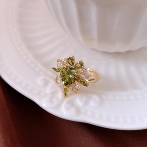 Detail of 14k gold plated ring featuring heart-cut green zircon and floral zircon cluster