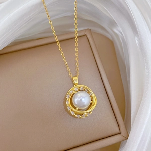 Close-up of golden spinning nest pendant with pearl and crystals on jewelry box