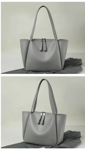 Detail view of grey tote bag with double zippers and textured pebble leather finish