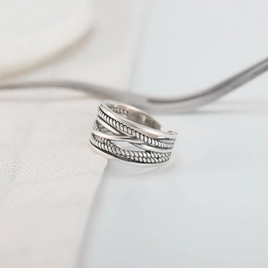 Macro shot of silver plated multi-layer twisted rope ring on soft white fabric background