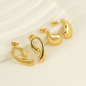 Detail of 18K gold-plated teardrop and twisted loop stud earrings set on a wavy stand