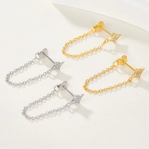 Detail view of elegant gold and silver star earrings with chains and zirconia