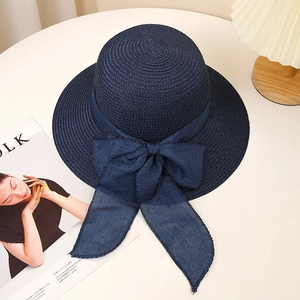 Navy blue straw sun hat with large bow detail for beach and outdoor protection