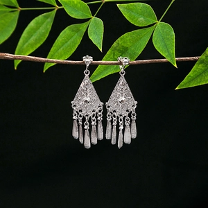 Close-up of silver geometric diamond base with metal tassels in retro ethnic style