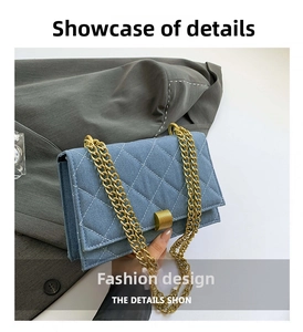 Close-up of blue denim crossbody bag featuring quilted stitching and gold chain strap