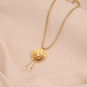 Gros plan d'un collier fleur doré avec pendentif perle élégant et détail de gland