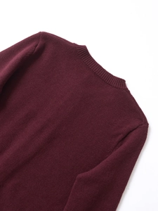 Detailed close-up of ribbed crew neck and fine knit texture on burgundy long sleeve sweater