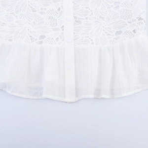 White lace blouse with puff sleeves and button detail showing pleated hem and texture