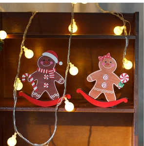 Macro view of wooden gingerbread man rocking horse decorations on a shelf with warm fairy lights