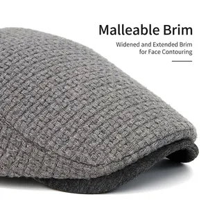 Grey knit newsboy cap with adjustable curved brim and warm textured fabric for winter