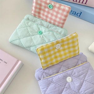 Close-up of quilted card holders with snap buttons in pastel mint, purple, and yellow