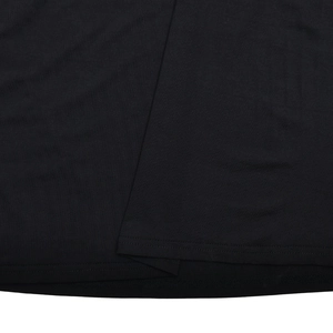 Close-up of the double-stitched hem and textured black knit fabric on a long dress