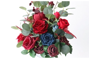 Detailed view of artificial silk roses in navy blue and burgundy with eucalyptus leaves