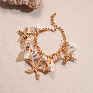Detailed close-up of gold layered starfish and seashell charms with imitation pearls