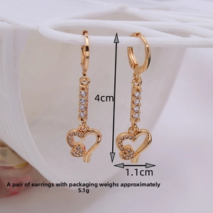 Detailed view of long gold heart earrings with clear zircon stones and 4cm length