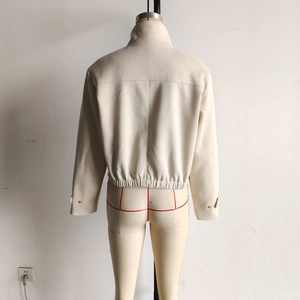 Back view of beige suede jacket showing the elastic hem and buttoned cuff details