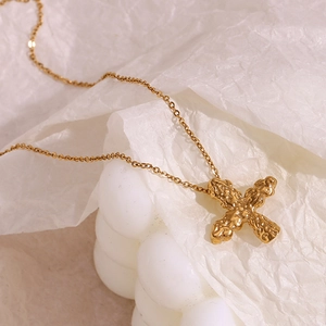 Detailed close-up of 18K gold plated cross pendant with unique hammered lava texture